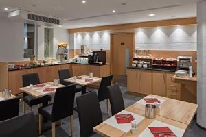 ein Restaurant mit Tischen und Stühlen und einer Küche in der Unterkunft City Hotel in Luxemburg (Stadt)