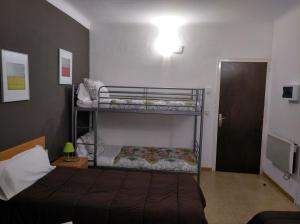 a bedroom with two bunk beds and a door at Hostal Juventus in Portbou