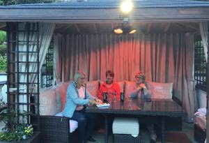 three people sitting at a table on a couch at Number Nine Accommodation in Downpatrick