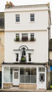 a white building with windows and a balcony at Vesta Central Bath Apartment in Bath