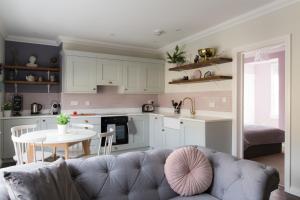 a living room with a couch and a table and a kitchen at Vesta Central Bath Apartment in Bath