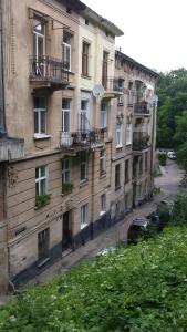 ein Apartmenthaus mit Balkon und ein Auto, das draußen parkt in der Unterkunft Near Citadel Apartment 2 in Lwiw