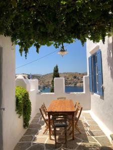 einen Holztisch und Stühle an der Seite eines Hauses in der Unterkunft Plesner House, Symi Greece in Symi