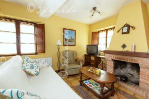 a living room with a couch and a fireplace at Apartamentos Casa Placida 1 in Frama