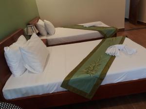 due letti in una camera d'albergo con asciugamani sopra di Tabii hotel a Da Nang