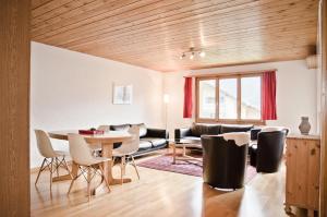 sala de estar con mesa, sillas y sofá en Apartment Aare 3.5 by GriwaRent AG, en Goldswil
