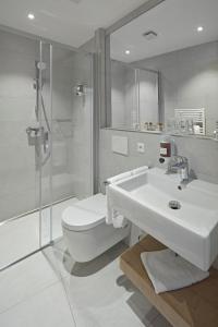 uma casa de banho com um lavatório, um WC e um chuveiro em City Hotel em Luxemburgo
