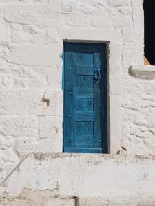 una puerta azul en el lateral de un edificio en White Dream, en Ostuni