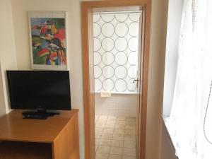 a door to a room with a television and a window at Pension Mona Lisa in Munich