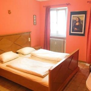two beds in a room with orange walls and a window at Pension Mona Lisa in Munich