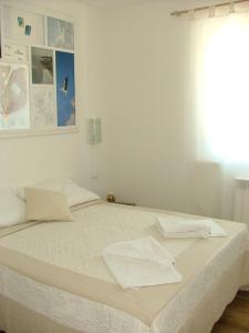 a white bed with white sheets and a window at Al Coppo in Sirolo