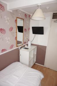 1 dormitorio con cama blanca y espejo en The Boundary Hotel - B&B en Leeds