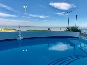 a swimming pool with a view of the ocean at False Bay Inn in Strand