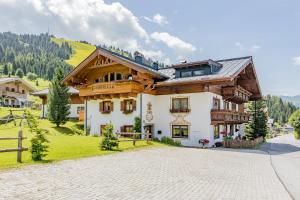 a large house in the mountains with a driveway at Haus Bergliebe in Maria Alm am Steinernen Meer