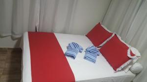 a bed with two pairs of slippers on it at Flat Visual do Porto in Fernando de Noronha
