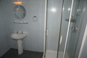 a bathroom with a shower, sink, and toilet at The Butlers Hotel in Leeds