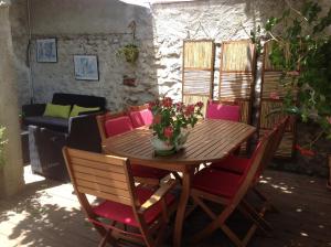 a wooden table and chairs with a vase of flowers on it at Casa Mia in Néfiach
