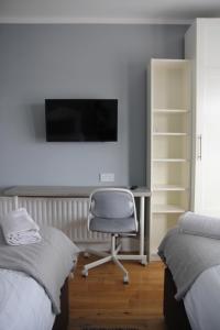 a bedroom with a desk and a chair and a tv at Greenmount Bed and Breakfast in Belfast