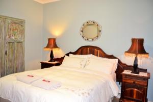 1 dormitorio con 1 cama con 2 lámparas y espejo en Versailles Self-Catering, en Wellington