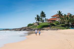 a man and a woman walking on the beach at Jetwing Saman Villas in Bentota