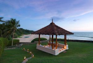 Jetwing Saman Villas في بينتوتا: شرفة مع أضواء على العشب بالقرب من المحيط