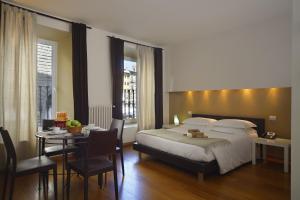 1 dormitorio con cama, mesa y comedor en Relais Piazza Signoria, en Florencia