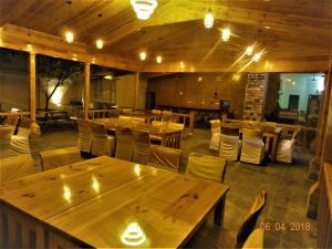 an empty restaurant with wooden tables and chairs at Hotel Sukoon in Dehradun