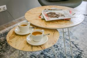 twee tafels met twee kopjes koffie en een tijdschrift bij Suitelodges Gooilanden in Loosdrecht