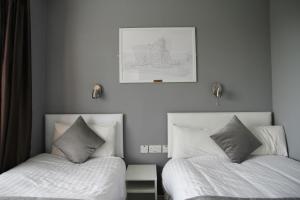 ベルファストにあるGreenmount Bed and Breakfastのベッドルーム1室(ベッド2台付)が備わります。壁に絵が描かれています。