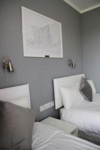 1 dormitorio con 2 camas y una foto en la pared en Greenmount Bed and Breakfast, en Belfast