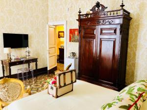 a living room with a large wooden cabinet in a room at Dimora Umberto in Catania