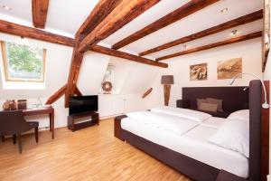Un dormitorio con una gran cama blanca y un escritorio. en Rebers Pflug, en Schwäbisch Hall