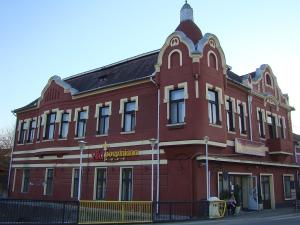 ein großes rotes Gebäude an der Ecke einer Straße in der Unterkunft VILA Corviniana in Hunedoara