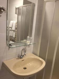 a white bathroom with a sink and a mirror at Hotel Villa Marina in La Maddalena