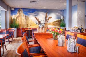 ein Restaurant mit Tischen und Stühlen und einem Wandbild in der Unterkunft Hotel Astoria in Noordwijk aan Zee