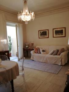 een woonkamer met een bank en een kroonluchter bij La casa di Anna in Viareggio