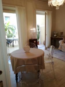 een eetkamer met een tafel en stoelen en een kroonluchter bij La casa di Anna in Viareggio