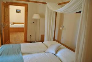 1 dormitorio con cama blanca y espejo en Grad Goričko en Grad