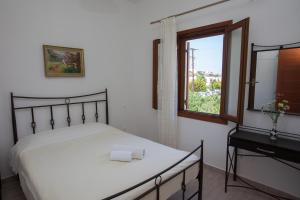 a bedroom with a white bed and a window at Villa Zacharo in Skala