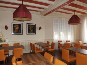 a dining room with wooden tables and chairs at Hotel Restaurant Le Parc in Moulins