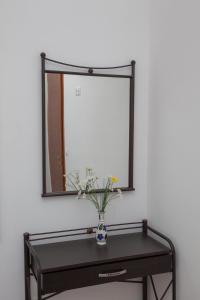 a mirror on a wall with a vase on a table at Villa Zacharo in Skala