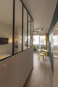 a room with glass walls and a kitchen with a table at Nicelidays - Le Berlioz - city central - 7min from beaches in Nice