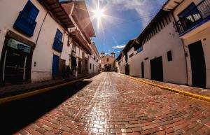 an empty cobblestone street in an alley with buildings at Cooper Hotel Boutique in Cusco