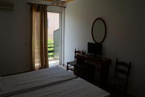 a bedroom with two beds and a mirror and a window at Lemonies in Diakopto