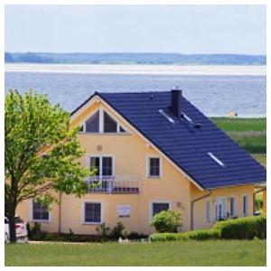 ein Haus mit einem Sonnendach darüber in der Unterkunft Ferienhaus Am Achterwasser in Ückeritz