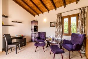 a living room with purple chairs and a table at Villa kortilles in Pyrgi