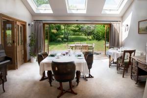 a dining room with tables and chairs and a window at Larkrise Cottage Bed And Breakfast in Stratford-upon-Avon