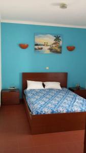 アルマカオ・デ・ペラにあるEdificio Belem Armação de Peraの青い壁のベッドルーム1室