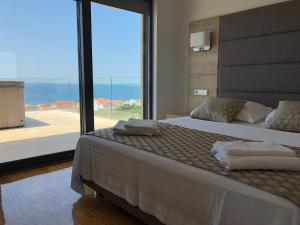 sypialnia z dużym łóżkiem i widokiem na ocean w obiekcie Luxury Apartments White Villa Violeta w mieście Mandre +37 zdjęć