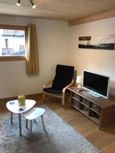 a living room with a tv and a chair and a table at Apartment Elin 1 in Le Châble